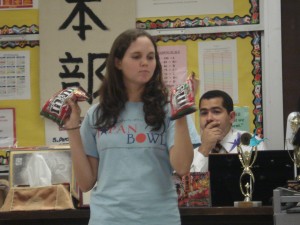 Grady in her senior year of high school as Japan Club vice president, explaining how to play go using M&Ms as Collazo looks on.